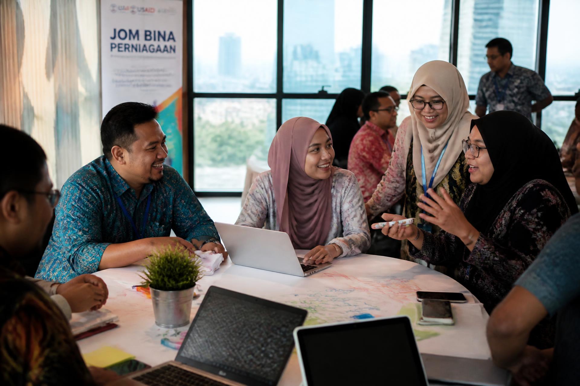 Malaysian small business owners collaborating during a community entrepreneurship workshop